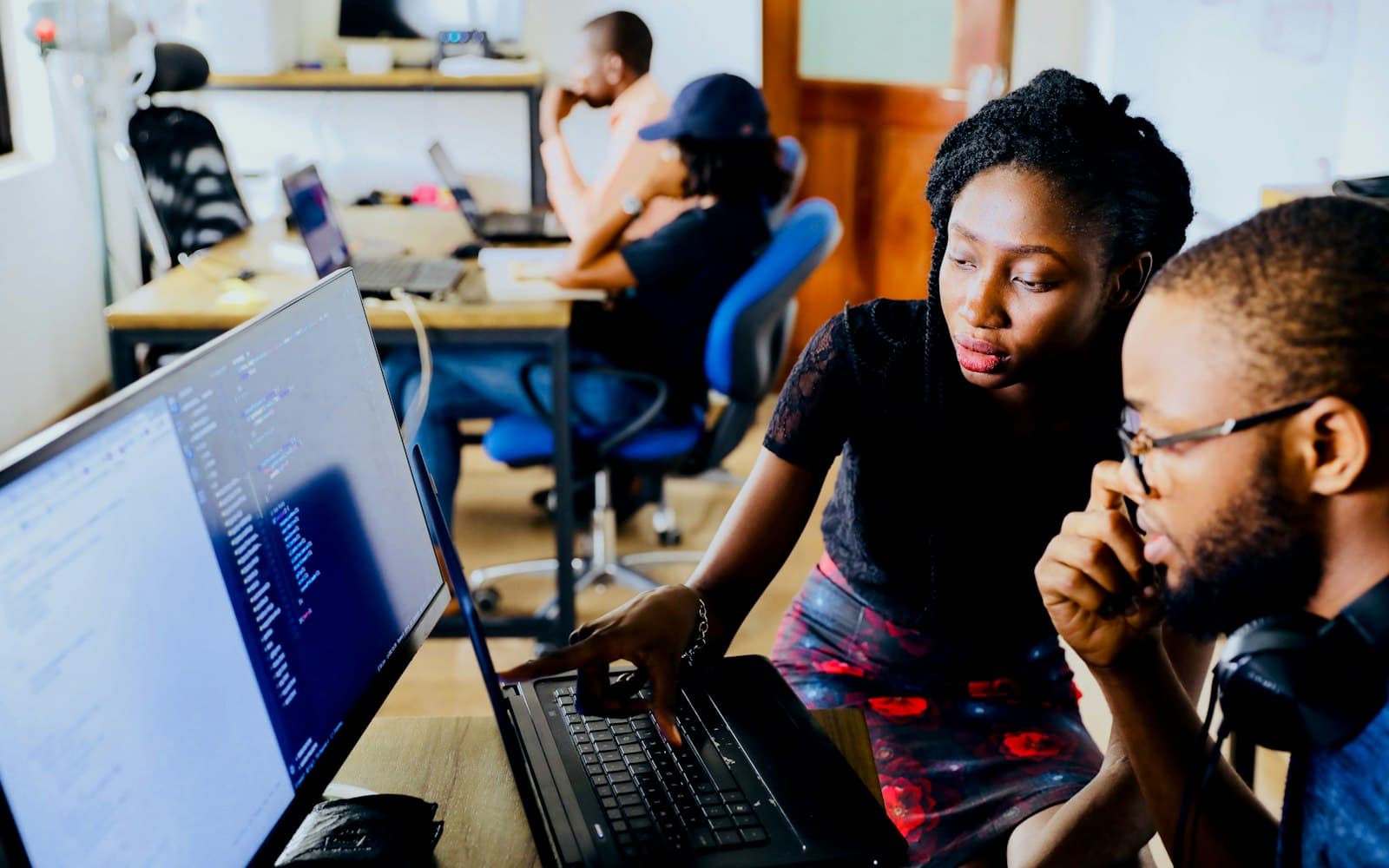 Twee collega's kijken samen mee op een laptop terwijl er gewerkt wordt