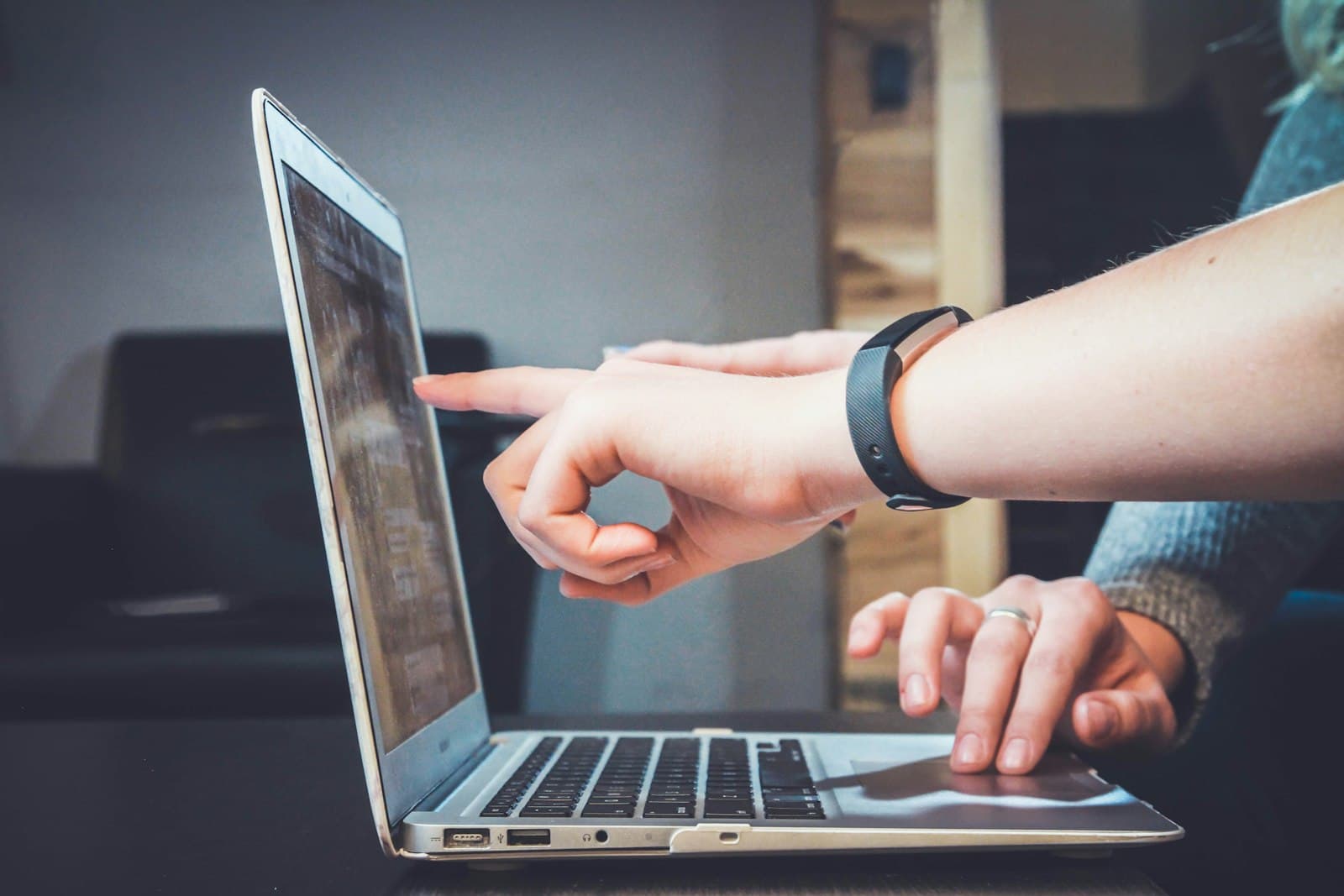 Hand wijst iets aan op een laptopscherm