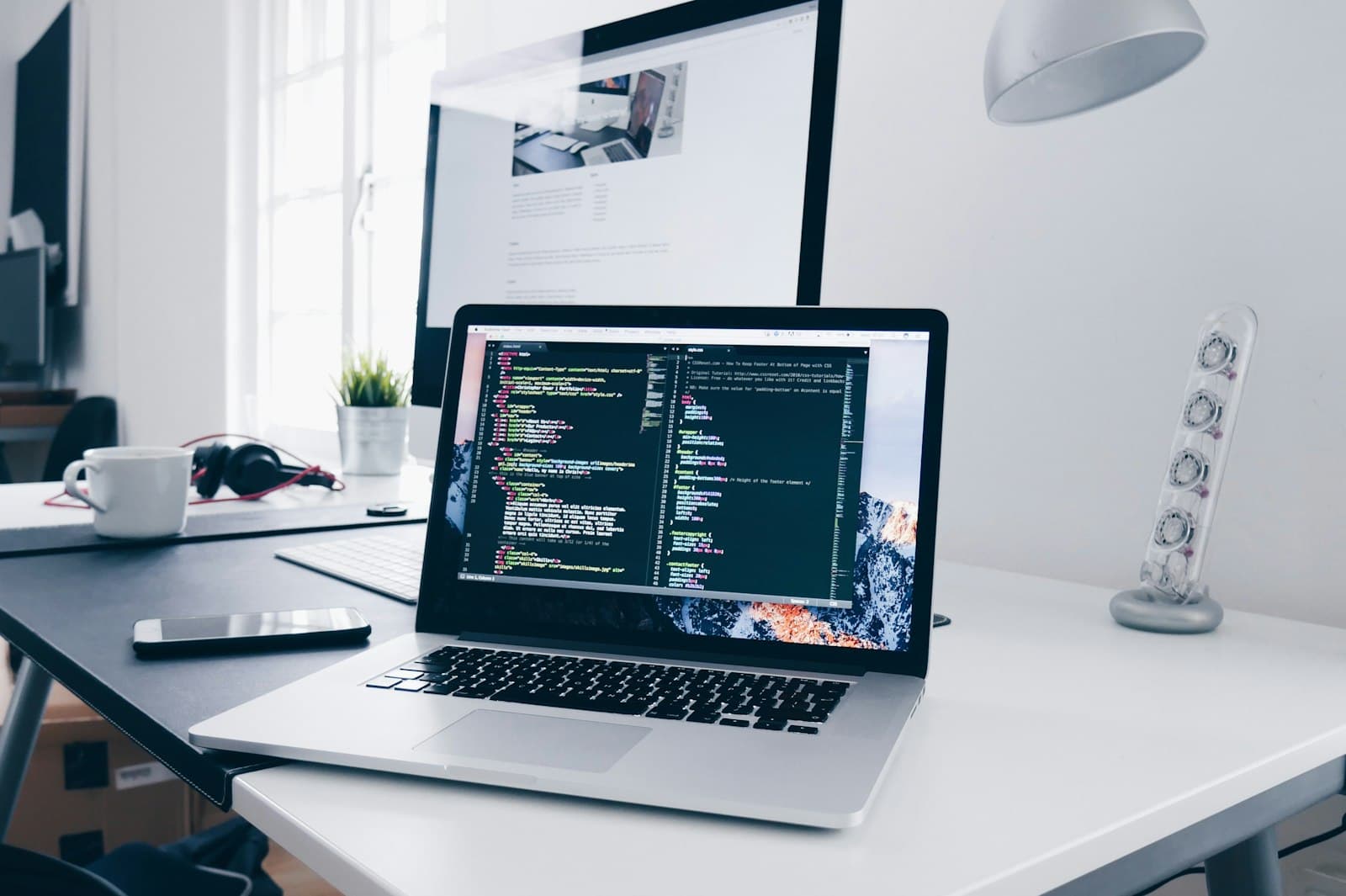 Laptop met code op een opgeruimd bureau